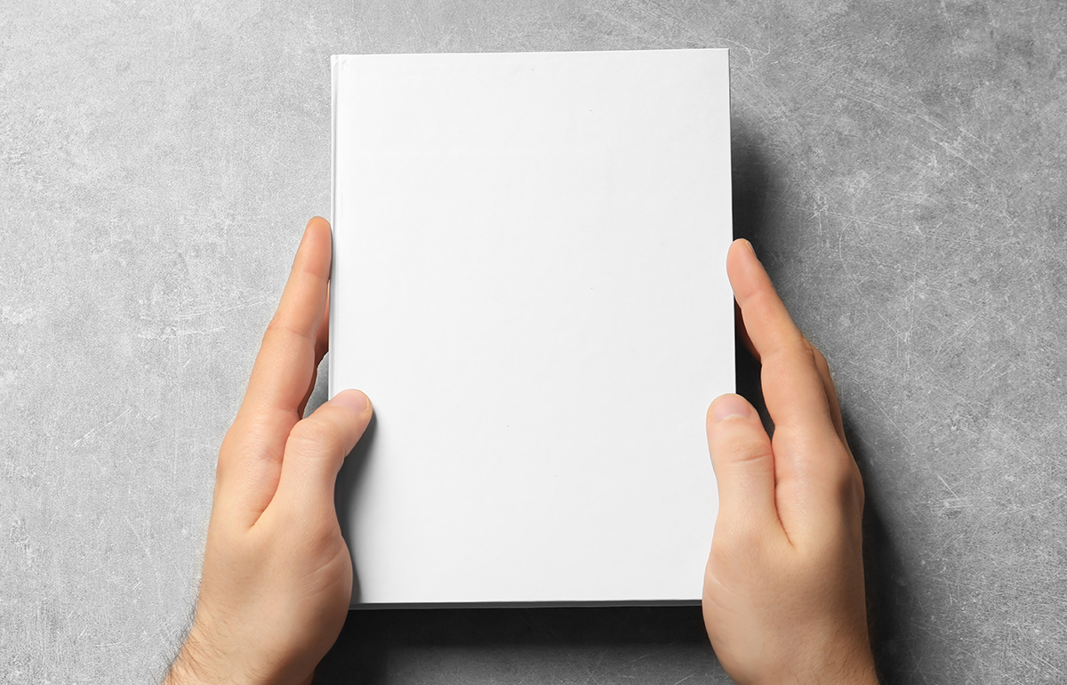 Man holding book with blank cover on grey background. Mock up fo